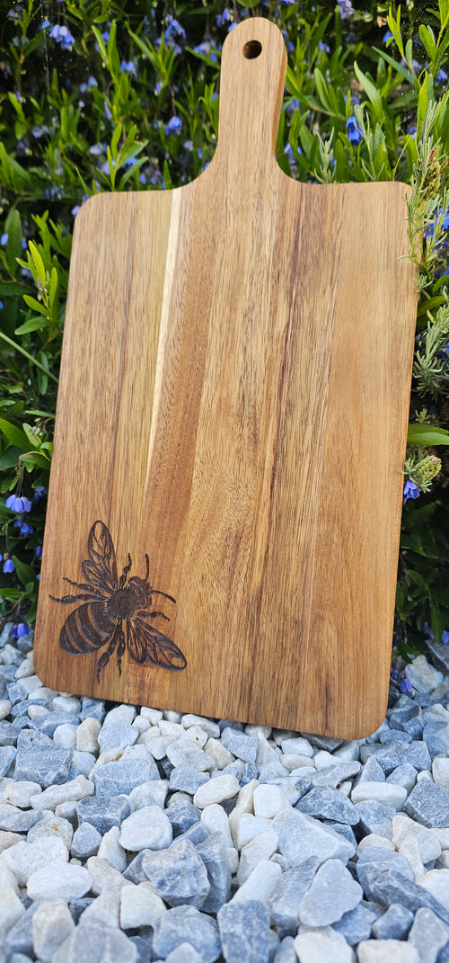 Wooden cutting board with a bee design on a natural background