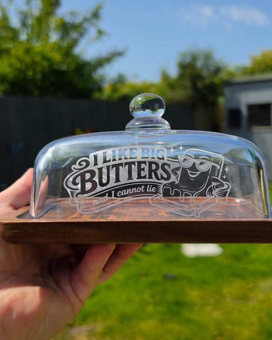 Butter dish with lid held by a hand against a blurred outdoor background