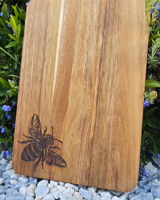 Wooden cutting board with a bee design on a natural background